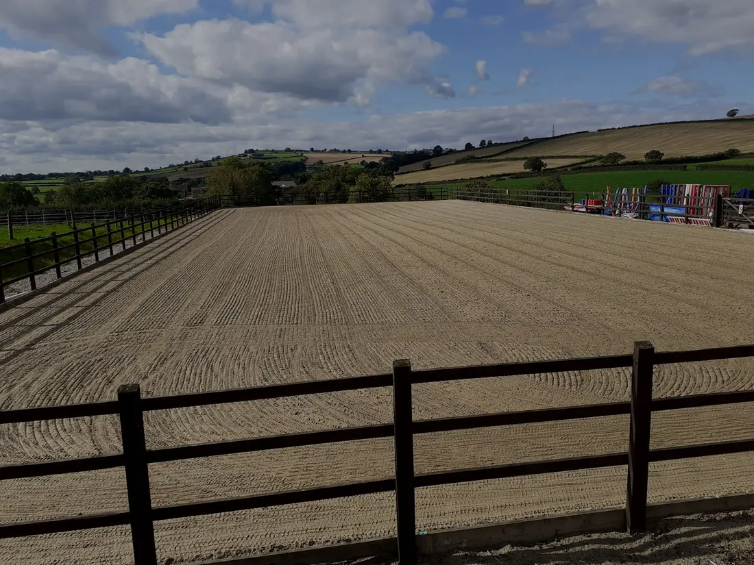 The floodlit all-weather arena at Maes Knoll Farm, looking out over the Chew Valley